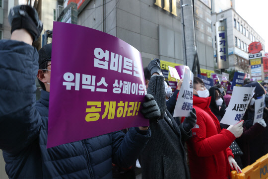 위믹스 사태 피해자 협의체 관계자들이 2일 오후 서울 강남구 업비트 앞에서 기자회견을 열고 위메이드가 만든 가상화폐 위믹스의 거래지원 종료(상장폐지)를 결정한 디지털자산거래소 공동협의체(닥사·DAXA)를 규탄하며 구호를 외치고 있다. [연합뉴스]